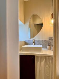 y baño con lavabo blanco y espejo. en Charmant loft intime, en Croisy-sur-Eure