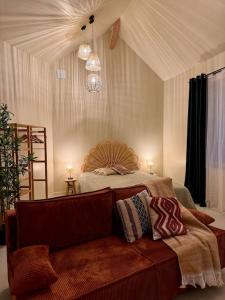 1 dormitorio con 1 cama con sofá enfrente en Charmant loft intime, en Croisy-sur-Eure
