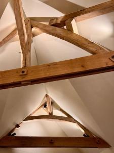 a ceiling of a room with wooden beams at Charmant loft intime in Croisy-sur-Eure