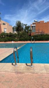 a swimming pool with two metal handles in front of it at RICO FLORES PALM BENSLIMANE in Mohammedia