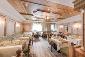 a restaurant with tables and chairs in a room at Hotel Sonklarhof in Ridanna