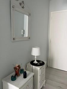 um quarto com um candeeiro numa cómoda e um espelho em Sea View Apartments near Athens Airport em Artemida