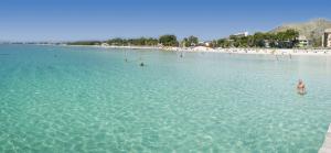 un grupo de personas en el agua en una playa en INNSiDE by Meliá Alcudia, en Puerto de Alcudia