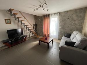 a living room with a couch and a table at CAMILLE à VER SUR MER in Ver-sur-Mer