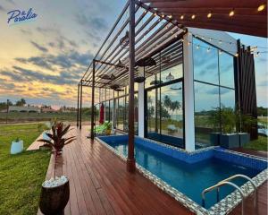 a villa with a swimming pool and a wooden deck at The Paralia in Brunibuma