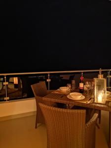 een tafel met stoelen en borden en wijnglazen bij Luxury Beach Condo Dehiwala Mt Lavinia in Watumulla