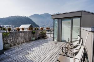 um deque com cadeiras no topo de uma casa em Luxus Penthouse mit Panoramablick em Bad Ischl