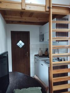 a kitchen with a loft bed and a kitchen with a table at Apartment Sever in Idrija