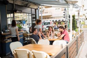 un grupo de personas sentadas en mesas en un restaurante en Sunny Home by the Sea en Tel Aviv