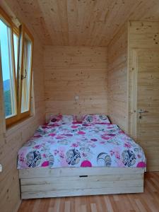 Ljubno的住宿－Glamping hiška Gril，木制客房内的一间卧室,配有一张床