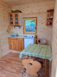a small kitchen with a table in a cabin at Glamping hiška Gril in Ljubno