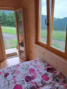 a bed in a room with a view of a window at Glamping hiška Gril in Ljubno