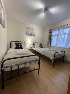 een slaapkamer met 2 bedden en een raam bij Spacious one bedroom apartment with free parking in Enfield
