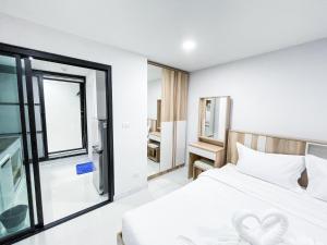 1 dormitorio con cama blanca y ventana en S&Y Apartment, en Ban Nong Waeng