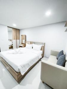 um quarto com uma cama grande e um sofá em S&Y Apartment em Ban Nong Waeng