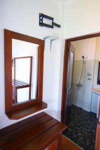 W łazience znajduje się drewniane lustro i prysznic. w obiekcie Ella Nine Arch lodge w mieście Ella