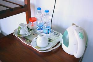 - un plateau avec des tasses et des bouteilles d'eau sur une table dans l'établissement Ella Nine Arch lodge, à Ella