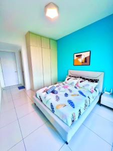 een slaapkamer met een bed met een blauwe muur bij Legoland-Happy Wonder Love Suite-Elysia- Max8pax-with Garden-Pool view in Nusajaya