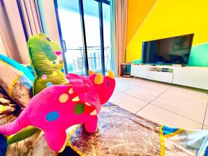 Legoland-Happy Wonder Love Suite-Elysia- Max8pax-with Garden-Pool view في نوساجايا: غرفة معيشة مع فيل وردي وتلفزيون