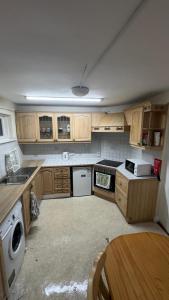 una pequeña cocina con armarios de madera y una mesa. en Triple Room Clontarf House-2 en Dublín