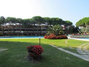 ein Park mit Blumen im Gras neben einem Gebäude in der Unterkunft Nice Apartment with Pool and Tennis court - Beach Place Included by Beahost in Bibione