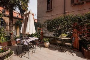 eine Terrasse mit Sonnenschirm und Tisch und Stühlen in der Unterkunft Appartamento Luxury Ai Greci in Venedig
