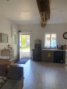 a living room with a couch and a kitchen at Charmante maison au bord des falaises in Les Authieux-sur-le-Port-Saint-Ouen