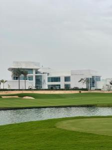 einen Golfplatz mit Grün und einem Gebäude in der Unterkunft شقة فندقية ALzorah Ajman - الزوراء عجمان in Ajman 