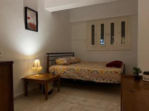 - une chambre avec un lit et une table avec une lampe dans l'établissement Cozy room in Degla Maadi, au Caire