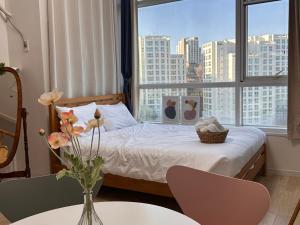 a bedroom with a bed with a view of a city at Seoul-lo Apartment in Seoul