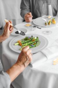 deux personnes assises à une table avec une assiette de nourriture dans l'établissement La Chartreuse du Bignac - Teritoria, à Saint-Nexans