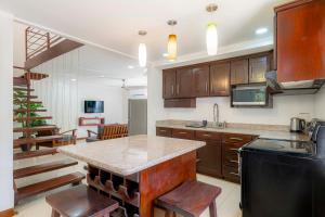 cocina con armarios de madera y encimera en Casa Mono del Río, en Matapalo