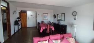 a living room with a pink couch and a table at Balcón del Mar in Monte Hermoso