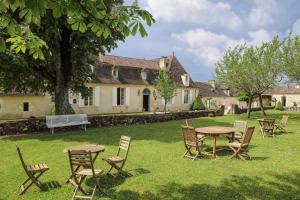 a group of tables and chairs in a yard at La Chartreuse du Bignac - Teritoria in Saint-Nexans