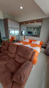 ein großes Bett und ein Sofa in einem Zimmer in der Unterkunft APARTEMEN THE BAY LAMPUNG CITY MALL in Bandar Lampung