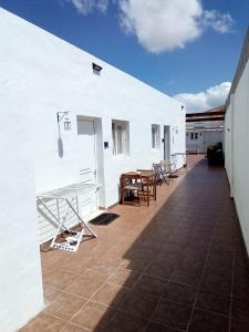 a white building with tables and chairs on a patio at Casa tomas C in Villaverde