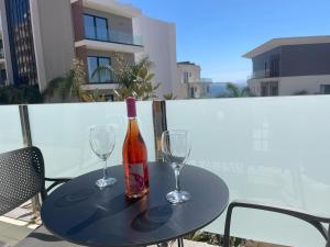 a bottle of wine sitting on a table with two glasses at 3B Suites Boutique Hotel in Sarandë
