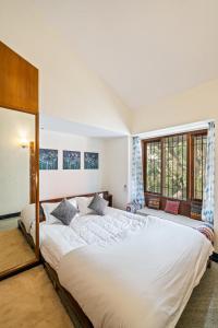 1 dormitorio con 2 camas y 2 ventanas en Namma Woodland, en Bangalore