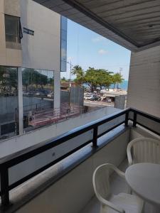 a balcony with a table and chairs and a view of the ocean at Beira Mar da Pajuçara in Maceió