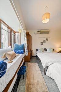 1 dormitorio con 2 camas y un taburete azul en Namma Woodland, en Bangalore