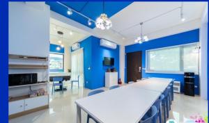 a kitchen with blue walls and a table and chairs at 宜蘭曼曼玩民宿 