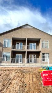 a large house with a dirt field in front of it at Ak Line in Bosteri