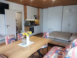 a living room with a wooden table and a kitchen at Studio Sonnenhang Würnitz in Würnitz