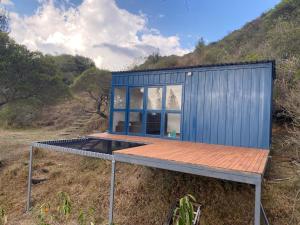 a blue shipping container with a wooden deck at Hotel Campestre los Duraznos in Cucunubá