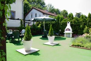 a patio with two potted plants and an umbrella at Apartmentpension Am Krongut in Potsdam