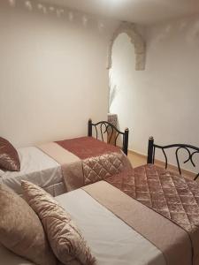 1 dormitorio con 2 camas y un arco en la pared en Two stand-alone flats on the cliff with wild animals, Galilee Sea & Mountains View en Safed