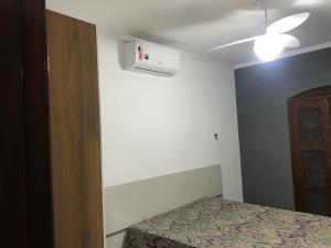 a bedroom with a bed and a ceiling fan at Beach House Ocean in Bertioga +3 photos