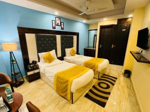 ニューデリーにあるAirport Hotel Shivaka Innのベッド2台とテレビが備わるホテルルームです。