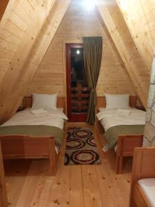 twee bedden in een kamer in een blokhut bij Vila Dobar Pogled in Ivanjica