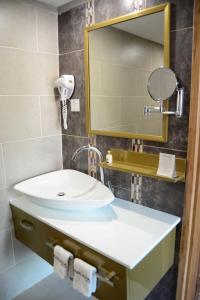 La salle de bains est pourvue d'un lavabo et d'un miroir. dans l'établissement Arcadia Suites - Kampala, à Kampala